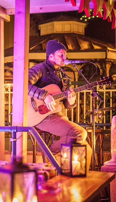 Musiker spielt Gitarre bei Abenddämmerung.