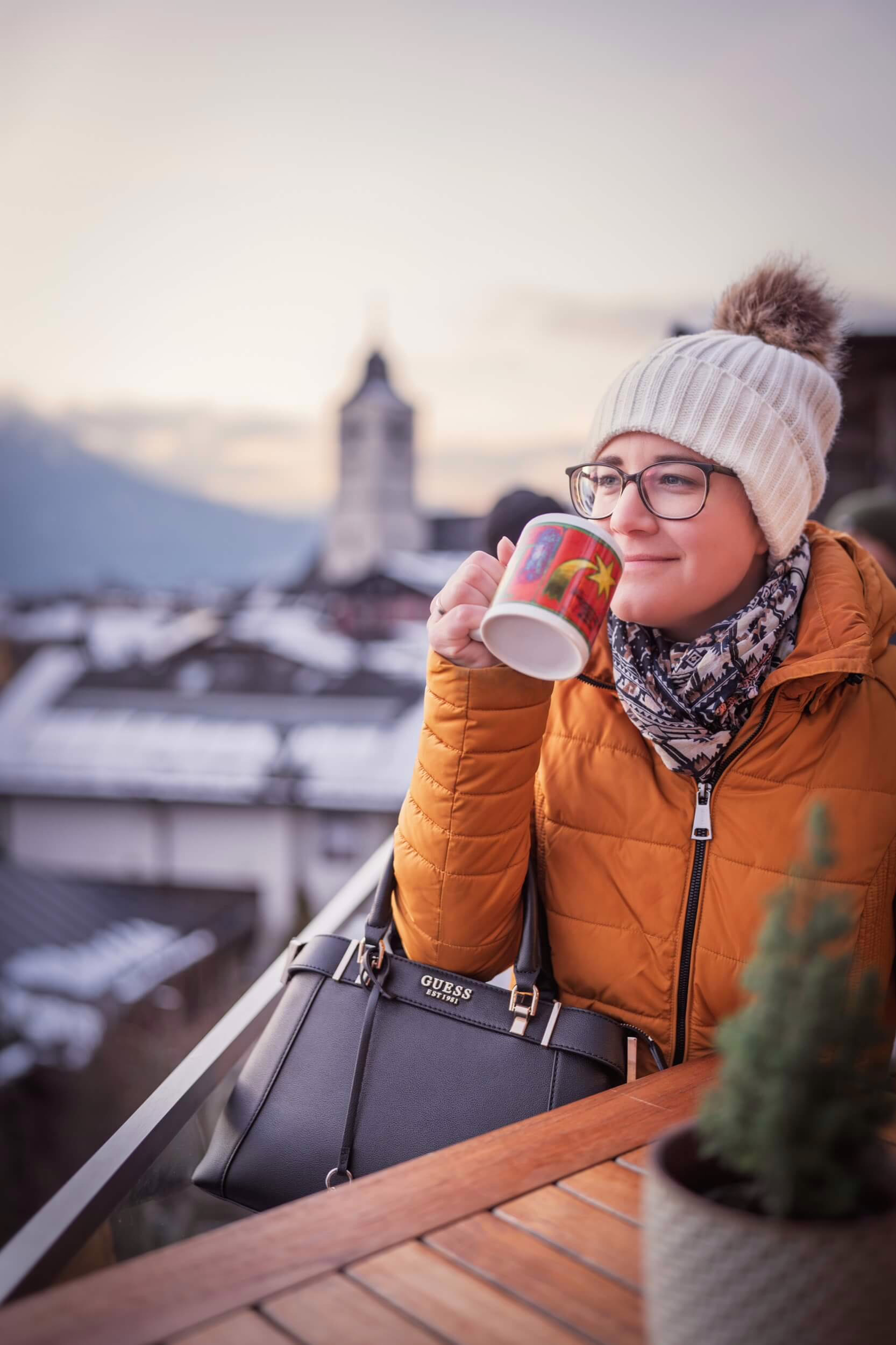 Frau mit Tasse auf Balkon