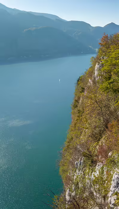 Bergsee mit grünen Ufern und Felsen