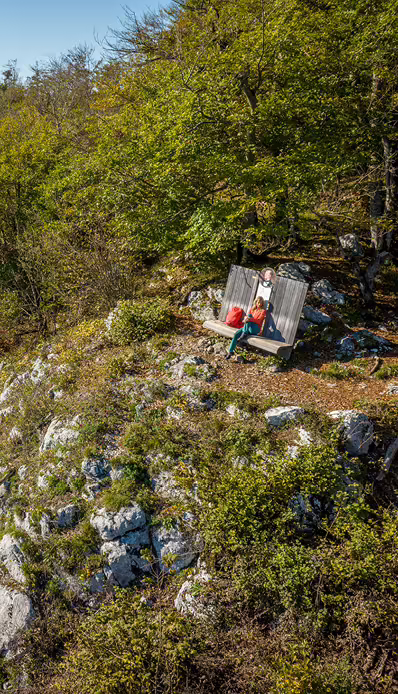 Person sitzt auf Bank in Natur