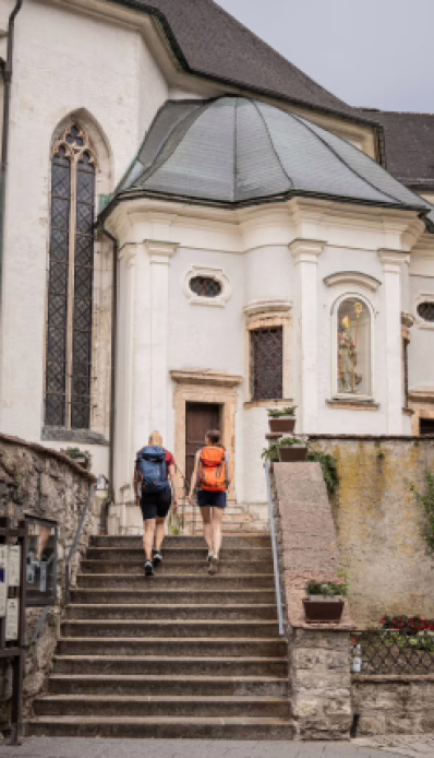 Wanderer gehen zur Kirche hoch.