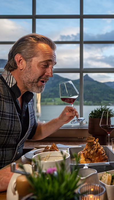 Mann genießt Wein am Tisch.
